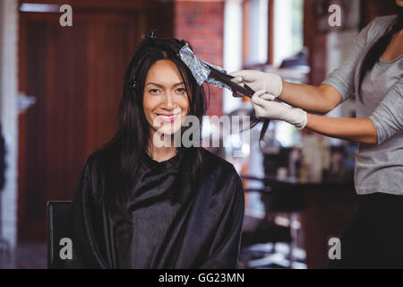 Hairdresser dyeing hair of her client Stock Photo