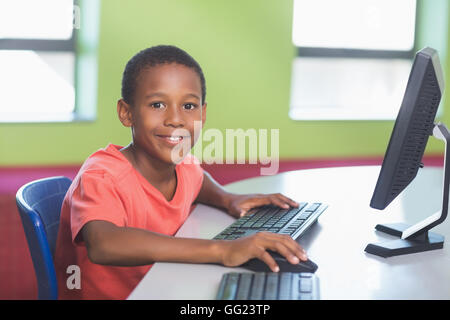 Schoolboy using computer in classroom Stock Photo