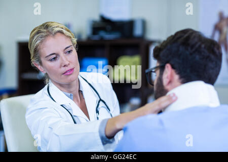 Physiotherapist examining neck of patient Stock Photo