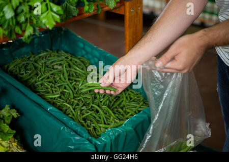 Man selecting green beans in organic section Stock Photo