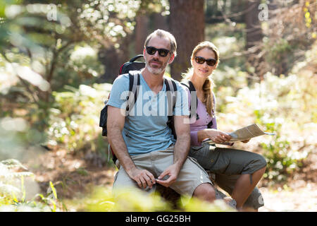 Hiker couple sitting on rock with map Stock Photo