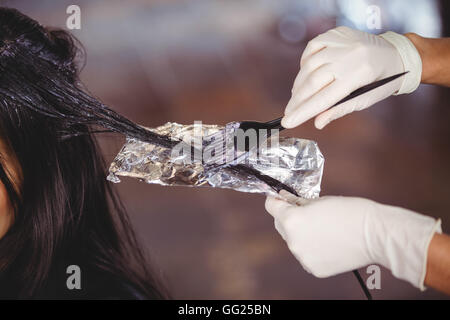 Hairdresser dyeing hair of her client Stock Photo