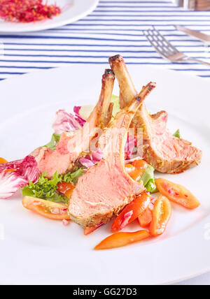 Roasted lamb rib chops with salad and tomatoes. Stock Photo