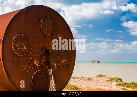 Rusty big barrel next to the sea at the open sky salt mine at La Guajira, Colombia Stock Photo