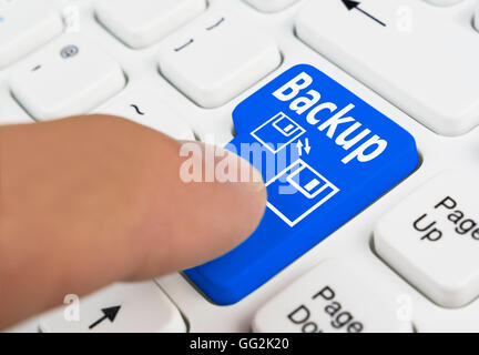 Finger pressing a computer backup button on a computer keyboard. Stock Photo