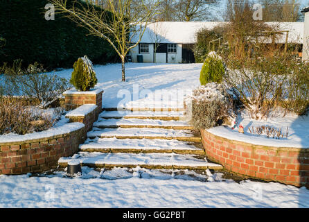 Winter in an English country garden with steps up to a higher lawn Stock Photo