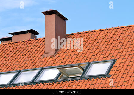 Tiled roof with a windows and chimney Stock Photo