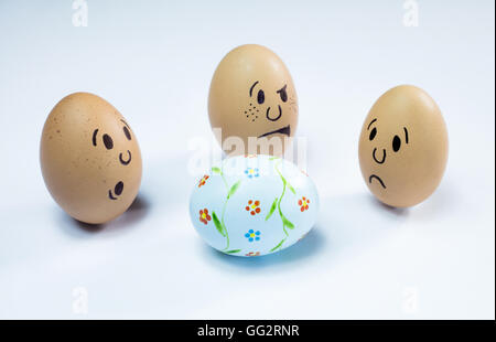 Egg faces are around an easter egg. Stock Photo