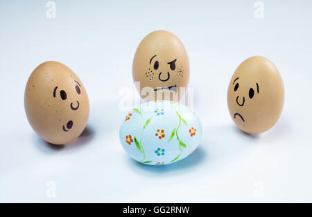 Egg faces are around an easter egg. Stock Photo