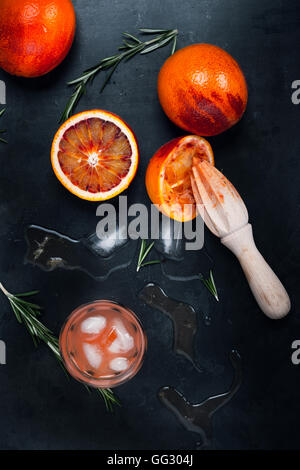 Fresh squeezed juice and blood oranges on gray background, top view Stock Photo