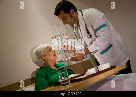 Doctor feeding his patient Stock Photo