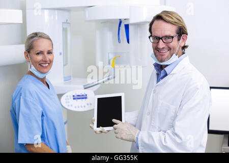 Dentist and dental assistant working on digital tablet Stock Photo