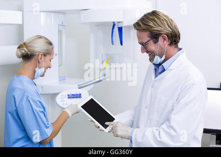 Dentist and dental assistant working on digital tablet Stock Photo