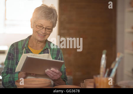 Female potter using digital tablet Stock Photo