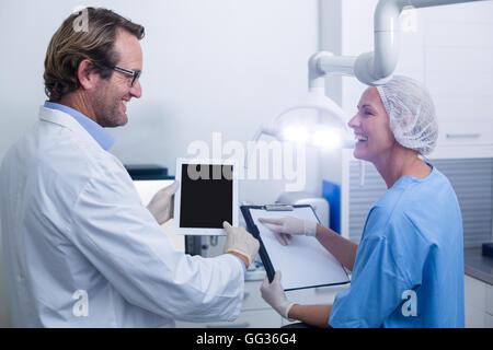 Dentist and dental assistant working on digital tablet Stock Photo