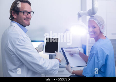 Dentist and dental assistant working on digital tablet Stock Photo