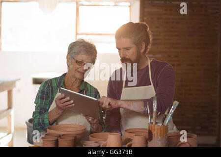 Male and female potter using digital tablet Stock Photo