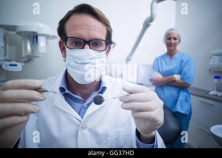 Dentist holding dental tools Stock Photo