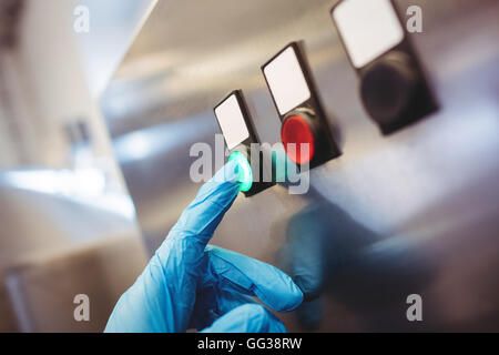 Brewery manufacturer hand on start button at control panel Stock Photo