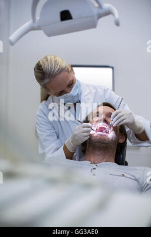 Dentist examining a patient with tools Stock Photo