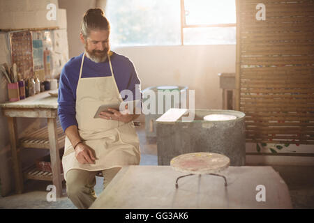 Male potter using digital tablet Stock Photo