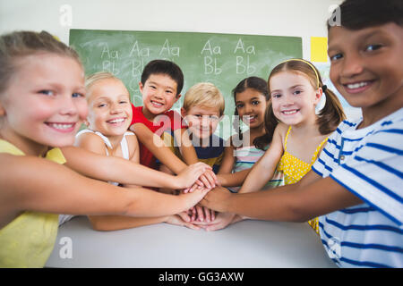 School kids stacking hands in campus Stock Photo - Alamy