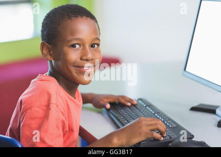 Schoolboy using computer in classroom Stock Photo