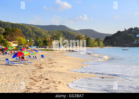 Golden sand, blue sky and colourful beach umbrellas at sunny Jolly Harbour, south-west Antigua Stock Photo