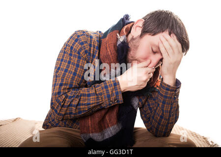 Closeup portrait of sick young man student, worker, employee with allergy, germs cold, blowing his nose with kleenex, looking very miserable unwell, isolated on white background. Flu season, vaccine Stock Photo