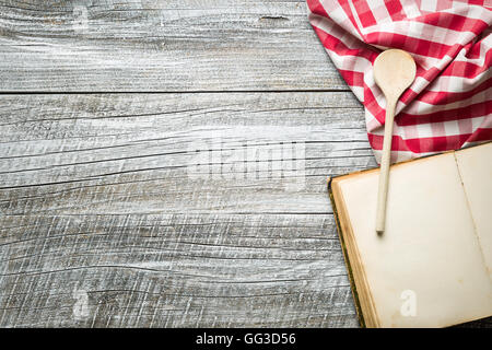 Cooking concept. Checkered napkin, wooden spoon and blank recipe book. Stock Photo