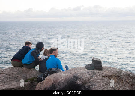 Cape Finisterre, Spain: Friends gathered at  Cape Finisterre Lighthouse at sunset after completing the Way of St. James. Nearby Stock Photo