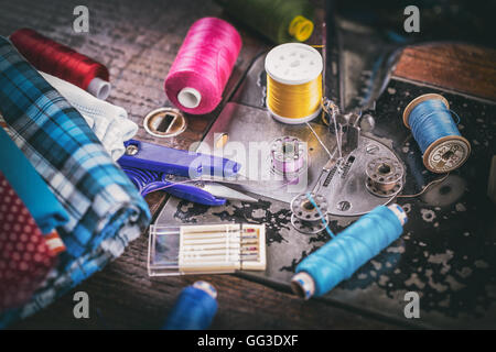 Old sewing machine detail with fabric and threads and scissors Stock Photo
