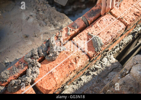 plasterer making up a brick wall with cement Stock Photo