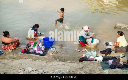 Women wash clothes in the Irrawaddy River, Mandalay Myanmar Stock Photo