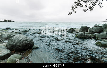 Rocky coast in Gulf of Finland and the waves on cloudy day Stock Photo