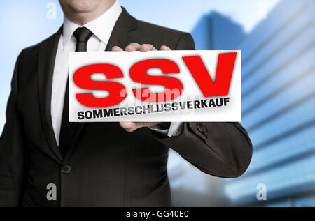 ssv sommerschlussverkauf (in german summer clearance sale) sign is held by businessman. Stock Photo
