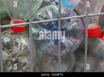 Plastic Recycling. Empty  plastic bottles in a recyclable garbage container, disposable drinking bottles in a public waste bin in the street. Stock Photo