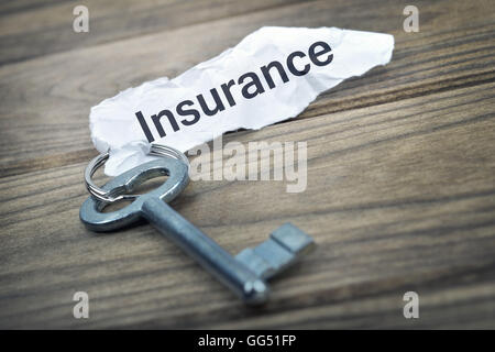 Key with message Insurance on wooden table Stock Photo