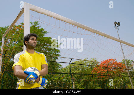 Goalkeeper stands next to the goal post Stock Photo