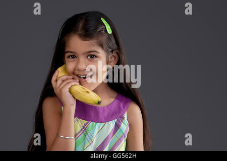 Girl using a banana as a phone Stock Photo