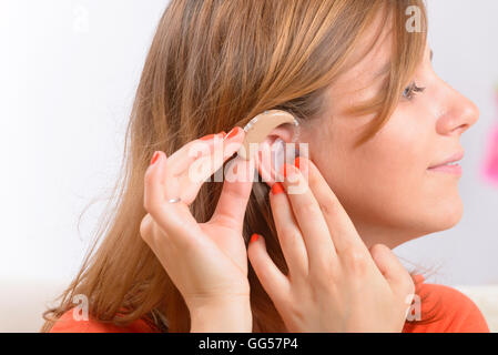 Putting on a deaf aid Stock Photo
