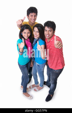 High angle portrait of college students gesturing thumbs up against white background Stock Photo