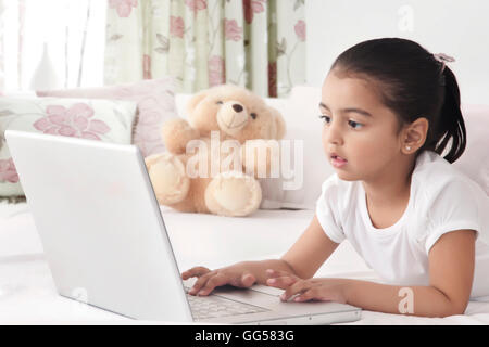 Girl using laptop in bed Stock Photo