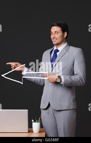 portrait-of-young-businessman-with-arrow-sign-pointing-sideways-in-gg588f.jpg