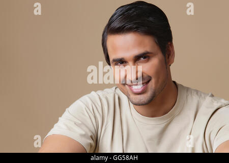 Portrait of happy Indian man over colored background Stock Photo