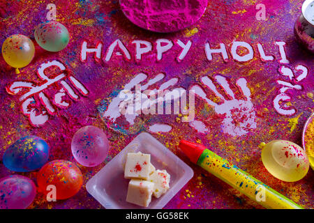 Squirt gun, water bombs, sweet food and colorful Holi power on rangoli Stock Photo