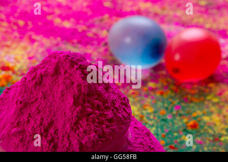 Close-up of pink Holi color powder with water bombs in background Stock Photo