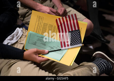 New United States citizen holds small American flag during swearing-in ceremony in San Antonio, Texas Stock Photo