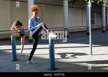 Young female athletes doing stretching exercise outdoors Stock Photo