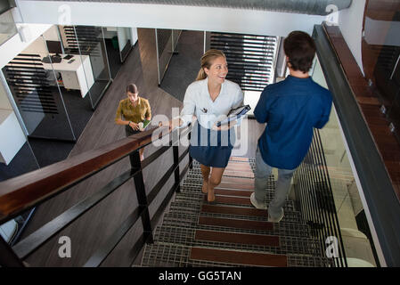 Happy businesswoman looking at her colleague on the staircase Stock Photo